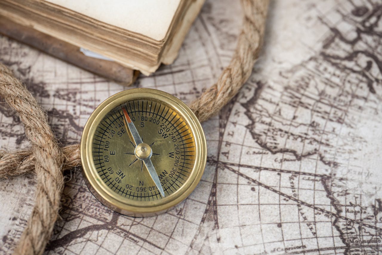 Services A close-up of a vintage compass on an antique world map, depicting navigation history.